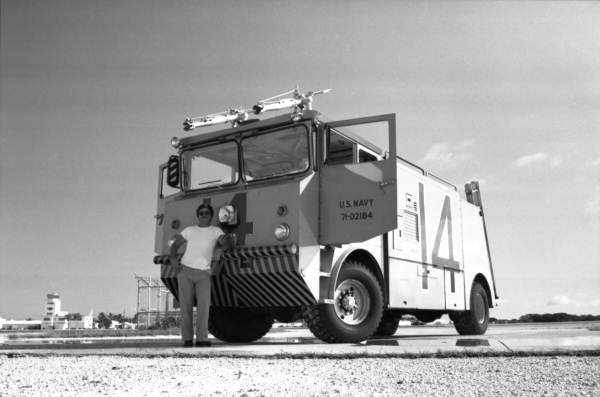 Firefighter Dale McDonald stands in front of MB-1A Oshkosh crash truck while on the "Hot Spot" for RW 7 at NAS Key West..