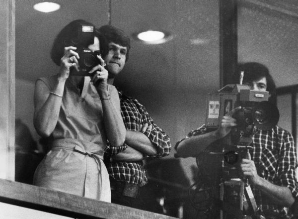 Mrs. Andrea Deratany takes pictures of her husband from the balcony - Tallahassee, Florida.