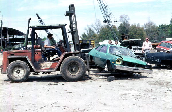 Remains of car being hoisted for crushing machine - Mims, Florida