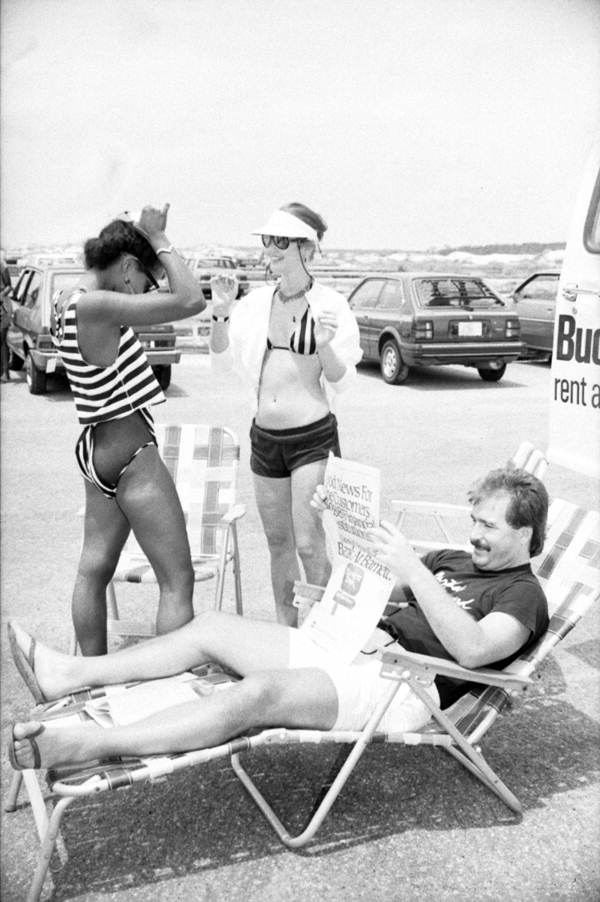 Fashion models and unidentified man near their car.