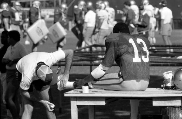 Football player, Kim Mack gets his foot bandaged - Tallahassee, Florida.