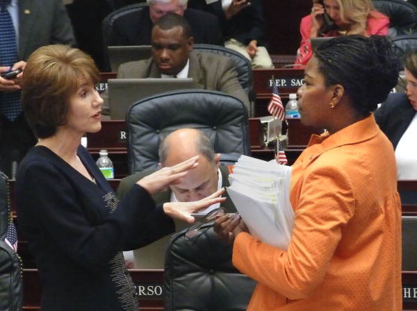 Representatives Marti Coley, R-Marianna, left, and Audrey Gibson, D-Jacksonville, conferring on the House floor in Tallahassee, Florida.