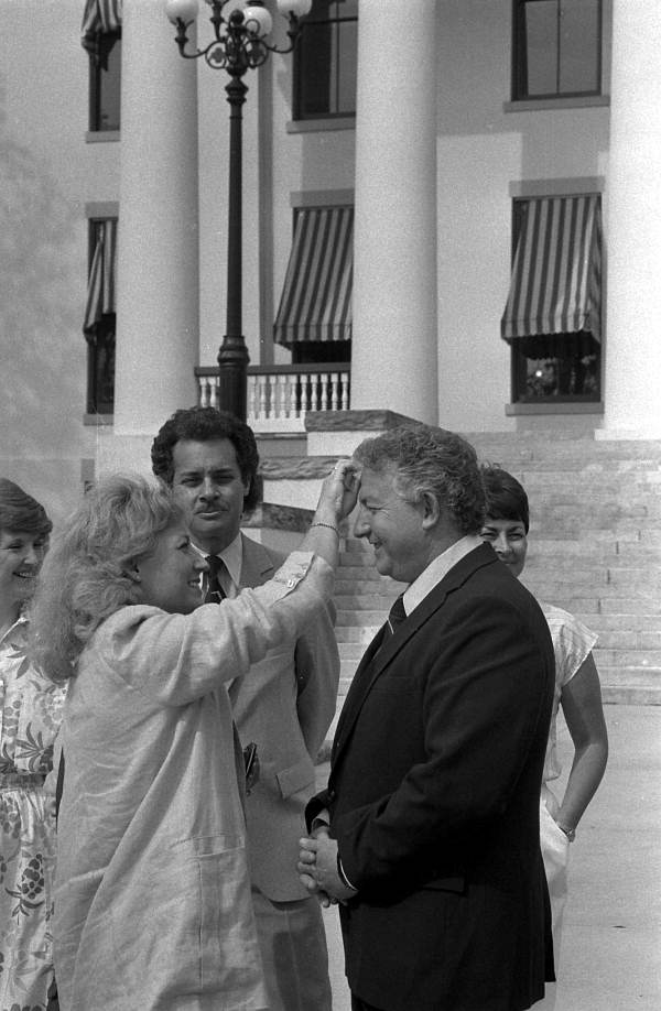 Judy Kutun prepares her husband for his commericial - Tallahassee, Florida.