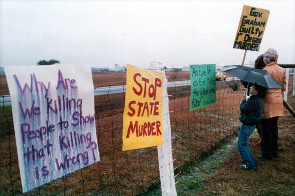 Death penalty protestors stands outside the fence - Starke, Florida