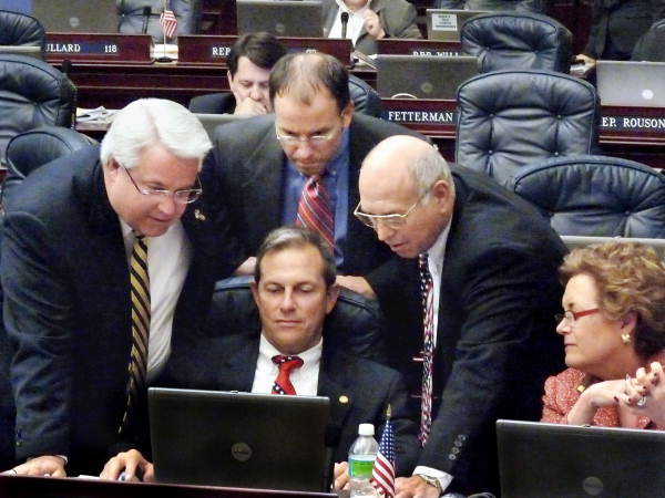 Members huddled around Florida State Representative Paige Kreegel during a short break on the House floor in Tallahassee.