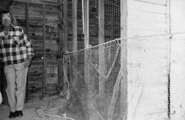 Net maker standing next to a fishing net in Key West, Florida.