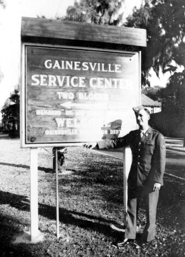 Unidentified serviceman standing next to sign pointing the way to the Gainesville Recreation Dept.'s Service Center.