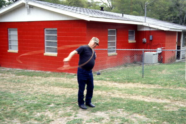 Whipmaker Ernest "Shelby" Braddock cracking some of the handmade cow whips at his home in De Land, Florida.