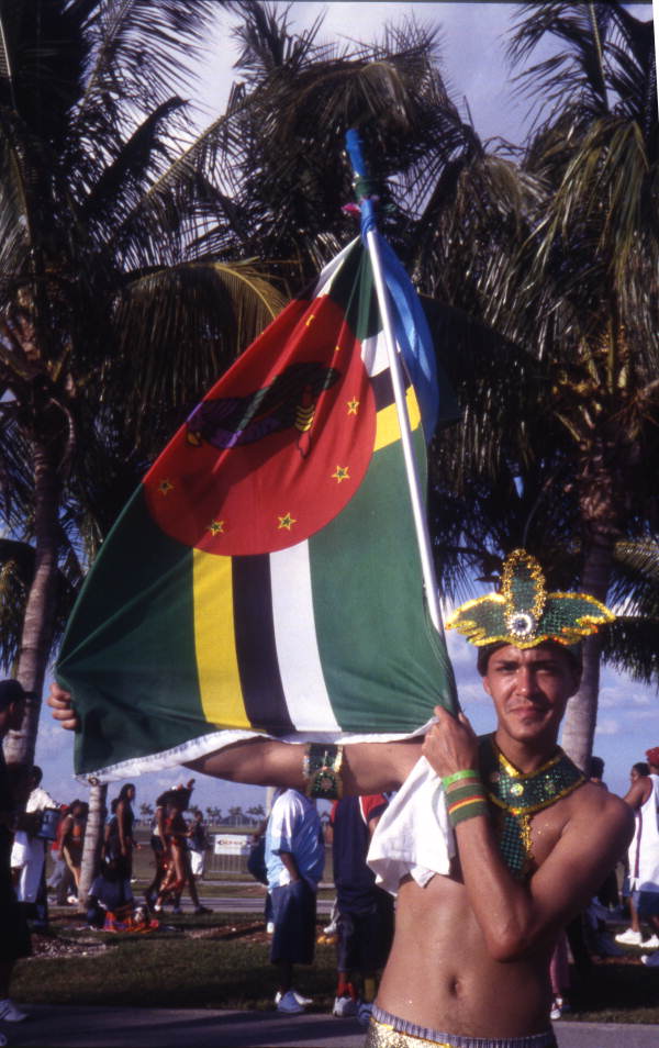 Caribbean Carnival parade participant at the Homestead Racetrack holding a flag of Dominica.