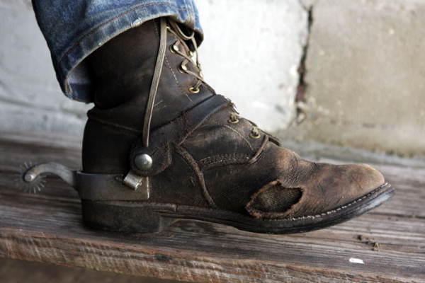 Close-up view showing the lace-up boot and spur of Doyle Rigdon.