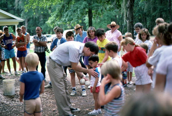 Folklorist Ormond Loomis instructing a boy on how to play the ball toss- Hamilton County, Florida