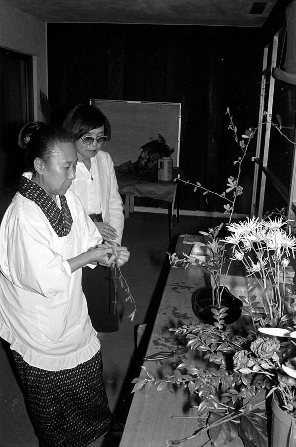 Sumino McGlamory observes as Atsuko Lefcourte makes Ikebana floral arrangement- Palm Beach, Florida.