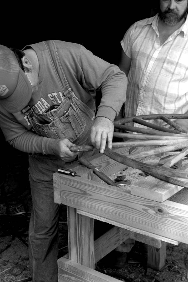 Wheelwright and coach maker John Luther and his apprentice Raymond Richardson working with a wagon wheel - McAlpin, Florida