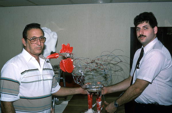 Isaac Duenas and apprentice and son David working on a rooster to be used in festival - North Miami Beach, Florida.