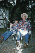 Cow whip maker George "Junior" Mills (r) cuts strips of buckskin while his apprentice J. Taylor Marcus plaits a whip - Okeechobee, Florida.
