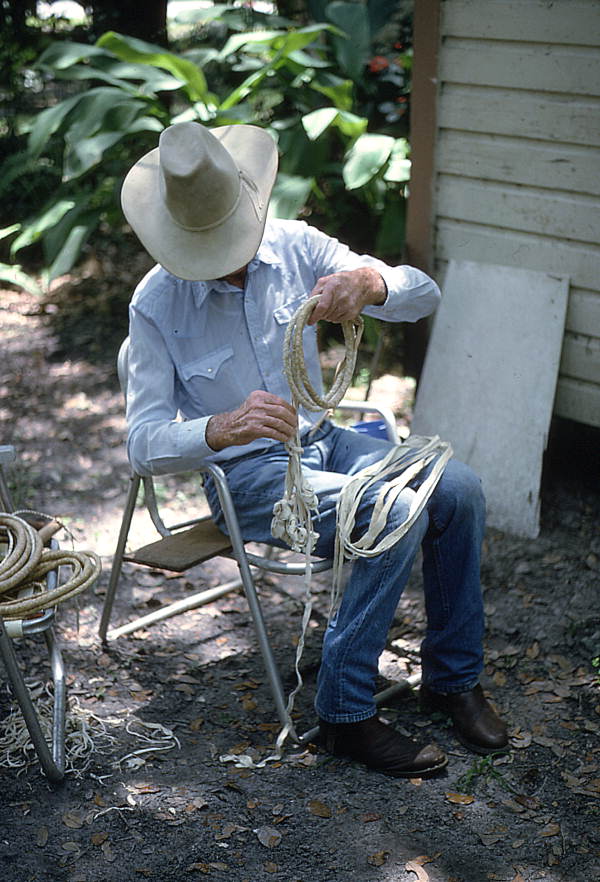 Cow whip maker George "Junior" Mills coiling sections of whip - Okeechobee, Florida.