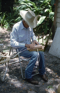 Cow whip maker George "Junior" Mills rolling a whip between blocks of wood - Okeechobee, Florida.