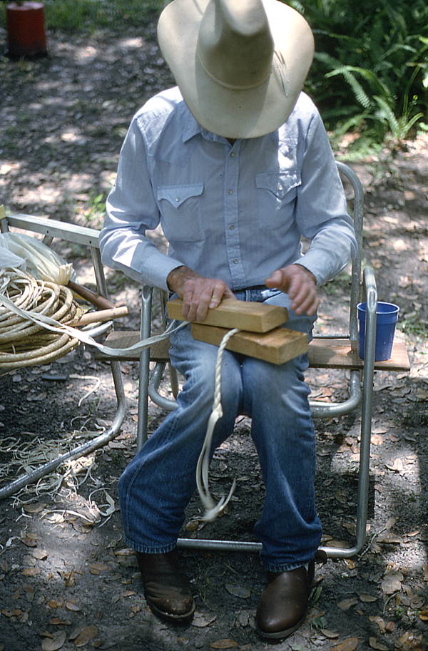 Cow whip maker George "Junior" Mills rolling a whip between blocks of wood - Okeechobee, Florida.