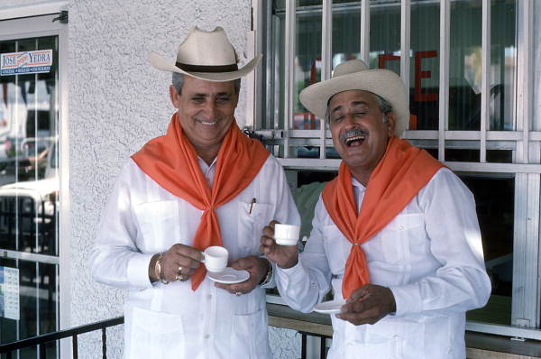 Cuban guajiro apprentice, Mario Brito, left, smiles as Meliton Perdomo sings a decima - Medley, Florida