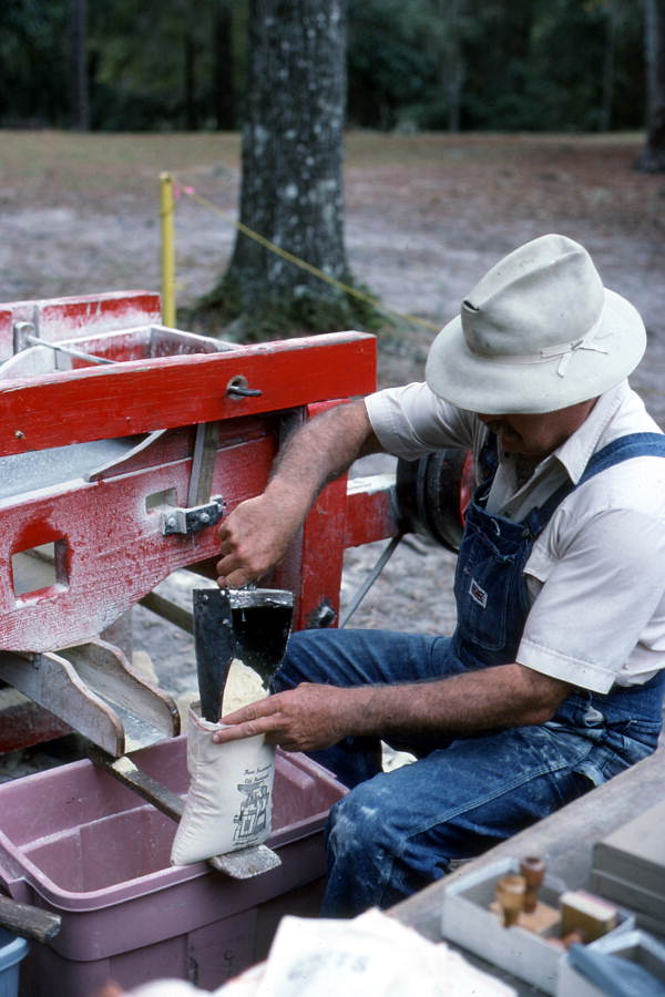 Thomas Register filling bag with cornmeal after milling - White Springs, Florida.