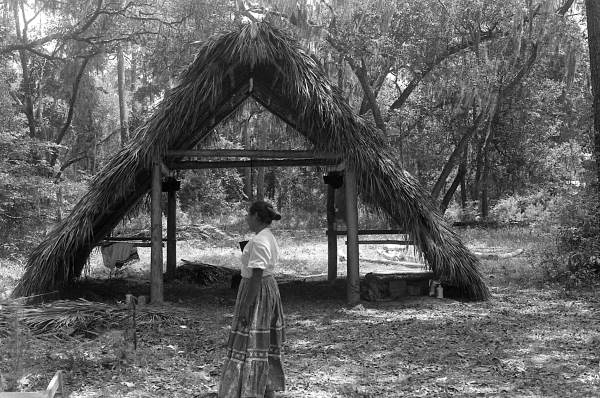 Woman in front of Seminole chickee at the 1985 Florida Folk Festival - White Springs, Florida
