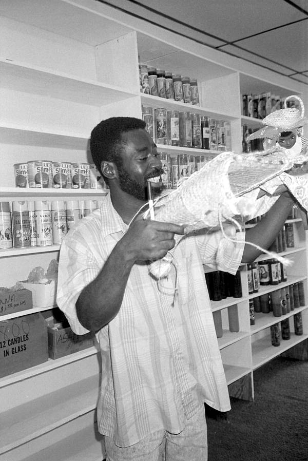 Man looking at crafts in Les Cousins, a shop in Little Haiti - Miami, Florida.