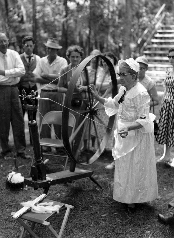Jessie Coker spinning cotton while observers look on- White Springs, Florida