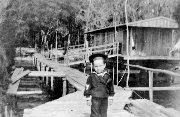 Nick Cole in sailor suit on walkway near shad fishing camp - Palatka, Florida.