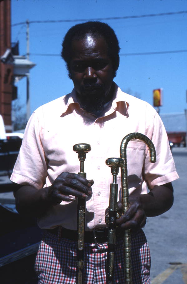 Smitty Bird holding walking canes he made - Monticello, Florida