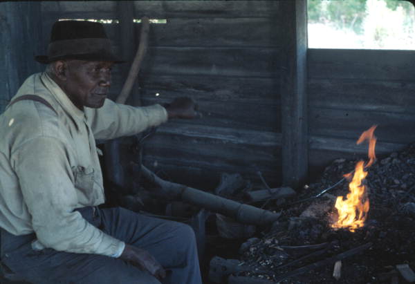 Blacksmith Thomas Rains tending to his fire - Monticello, Florida