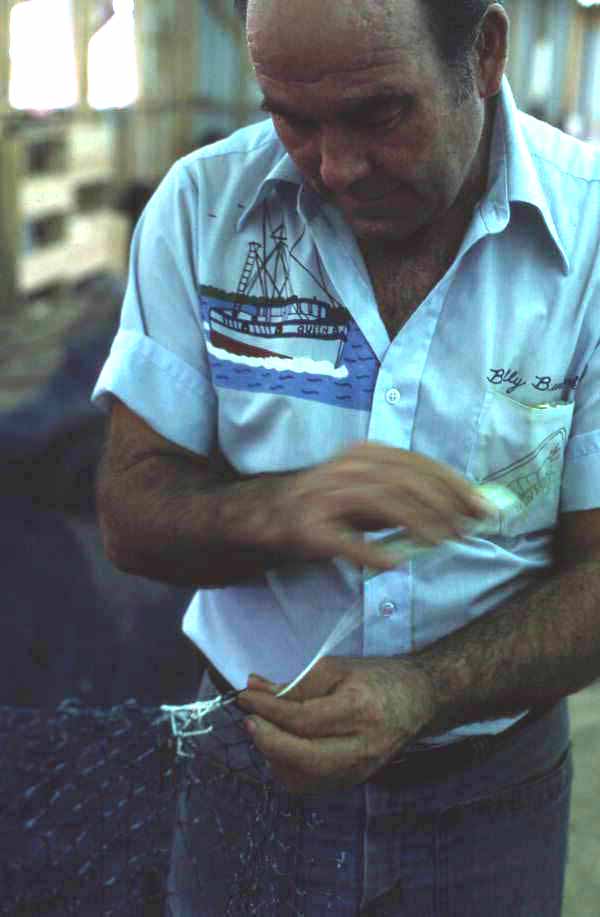 Net maker Billy Burbank II in the middle of repairing a fishing net - Fernandina Beach, Florida