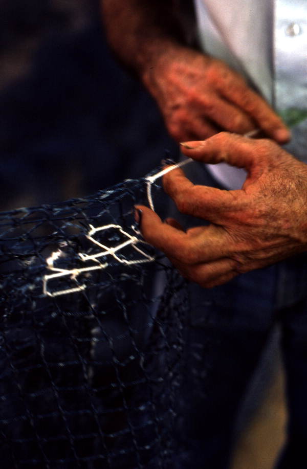 Net maker Billy Burbank II at work repairing a fishing net - Fernandina Beach, Florida