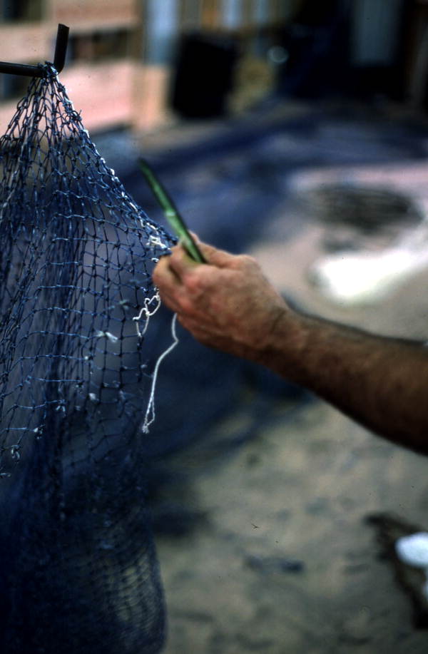 Net maker finishing repairs of a fishing net - Fernandina Beach, Florida