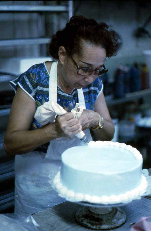 Cuban American woman decorating a cake at the Cafe Cubano in Little Havana - Miami, Florida.