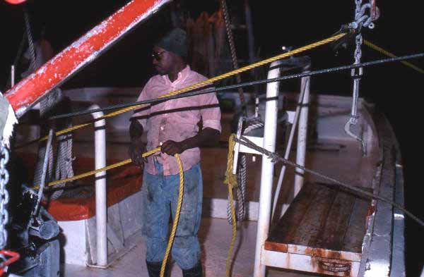 Shrimper working rope aboard shrimp boat - Fernandina Beach, Florida