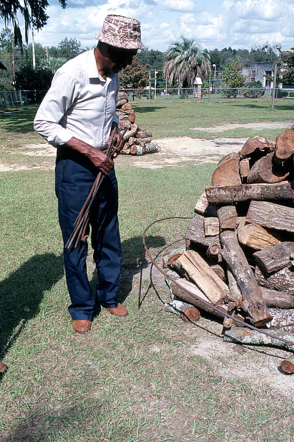 Man getting the firewood ready for a mullet roast - Monticello, Florida