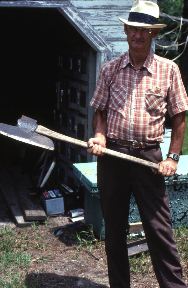 Wood carver Charlie Lewis holding an axe - Perry, Florida.