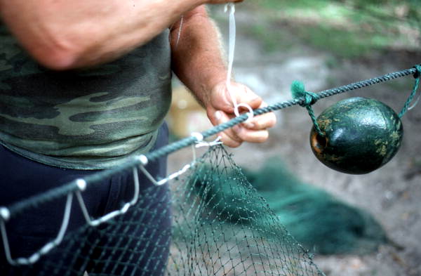 Net maker Martin Cooper repairing a shrimp trawl net - Jacksonville, Florida