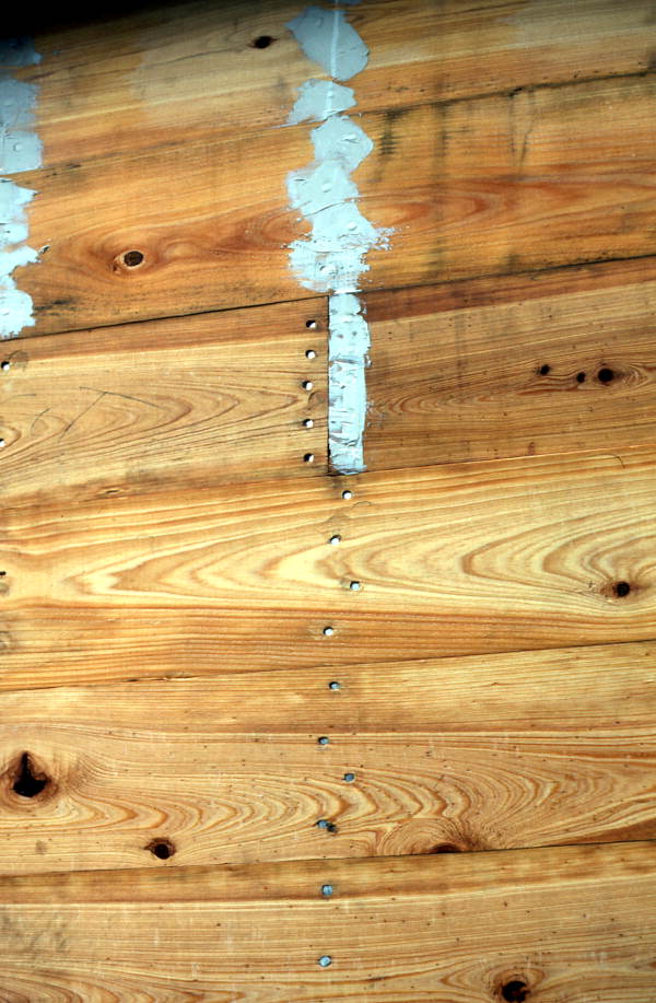 Calking over nails on wooden planking - Jacksonville, Florida.