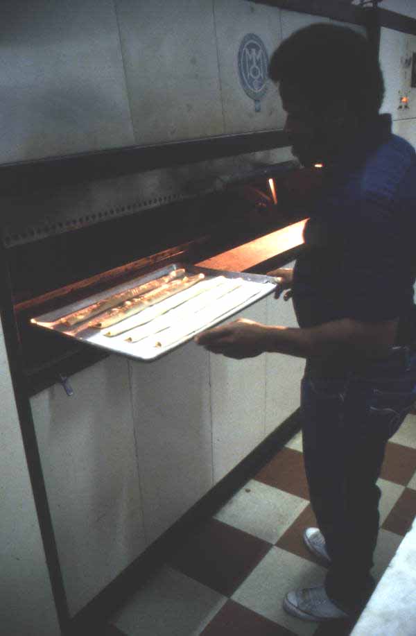 Jimmy Walton placing guava pastries into the oven - Jacksonville, Florida.