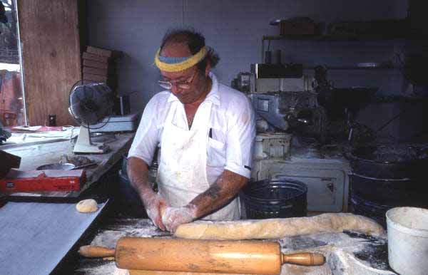 Marty Kaufmann breaking off pieces of dough into knishes at Suzanne's Foods - Miami, Florida.