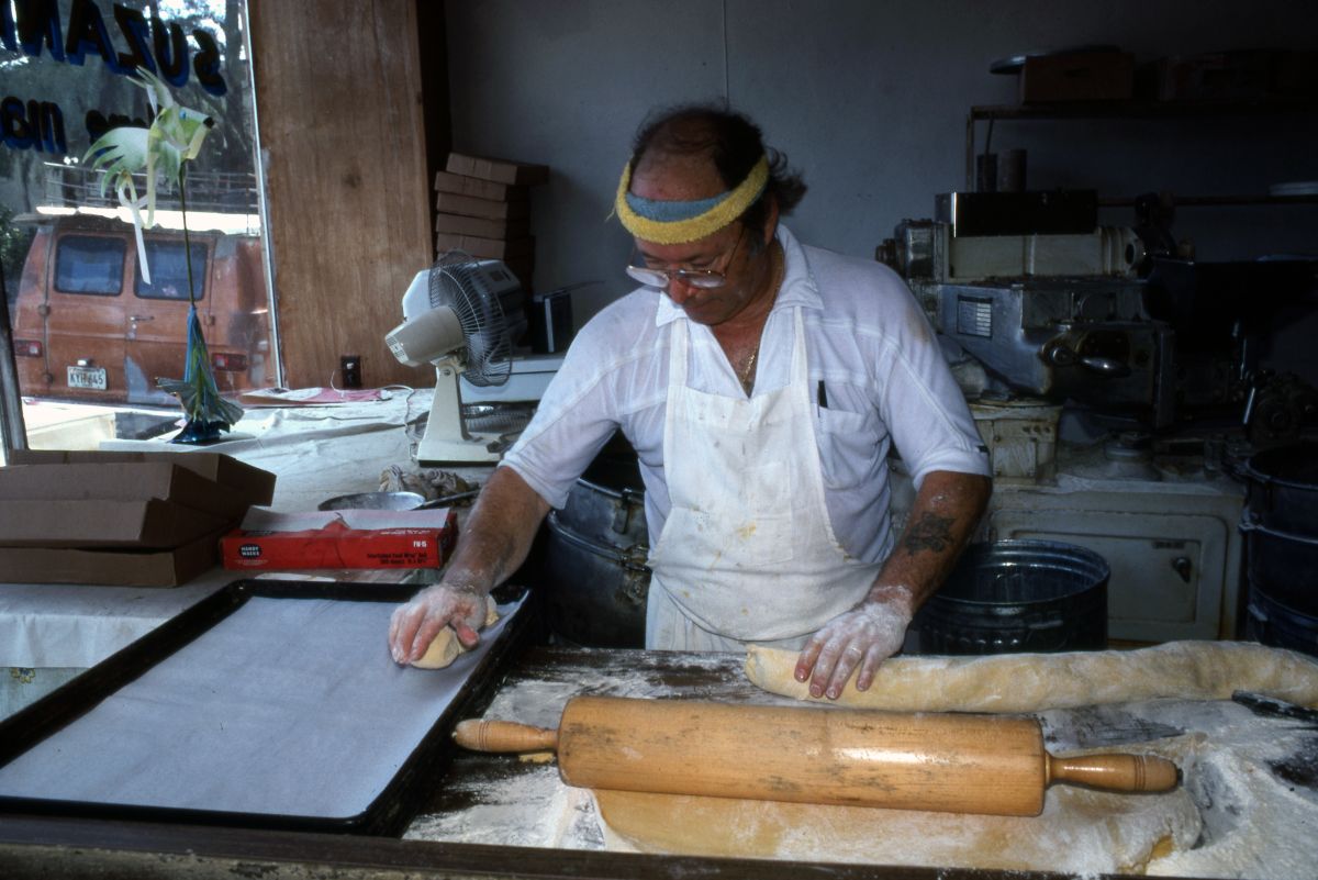 Marty Kaufmann breaking off pieces of dough into knishes at Suzanne's Foods - Miami, Florida.