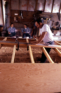 Bobby Shiver building an oyster skiff while two men watch - Eastpoint, Florida