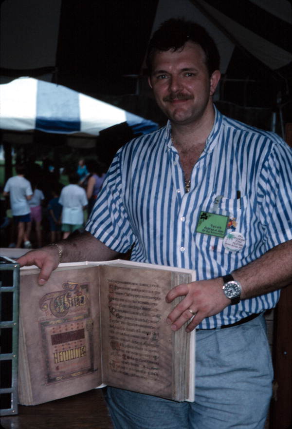 William Ramoutar holding up a copy of the Book of Kells at the 1991 Florida Folk Festival - White Springs, Florida
