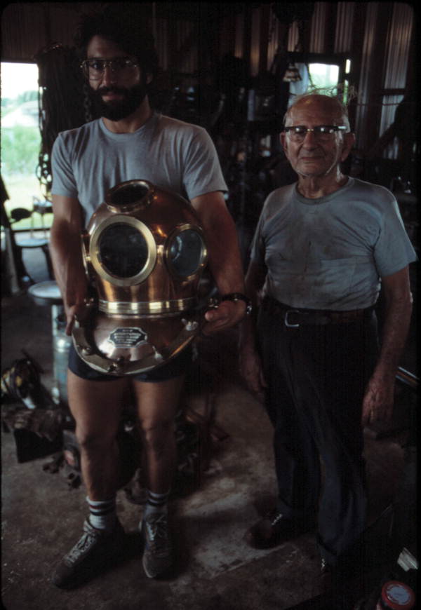 Nick Toth holding a Greek diving helmet while Antonios Lerios looks on - Tarpon Springs, Florida
