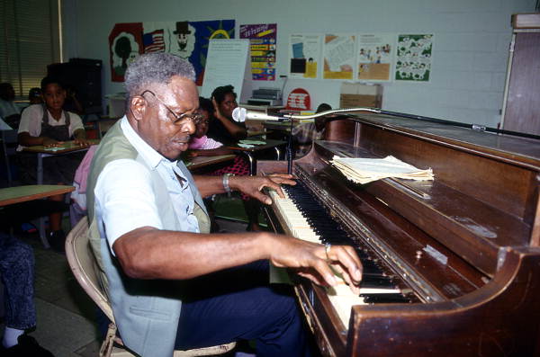 Alex McBride playing blues piano for John E. Ford Elementary fifth grade students - Jacksonville, Florida
