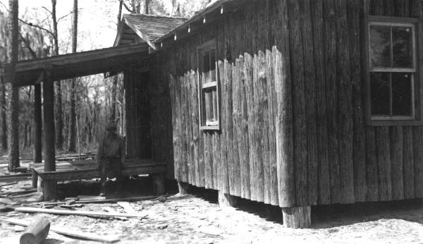 Oleno forestry training camp (Oleno State Park) caretaker sitting on porch of caretaker's cabin during construction by the CCC - Columbia County, Florida.