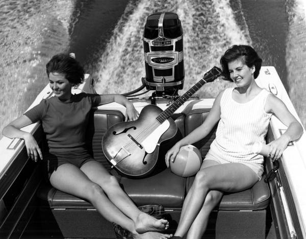 Young women on a boat with a guitar .