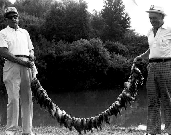 Unidentified men hold their catch of fish