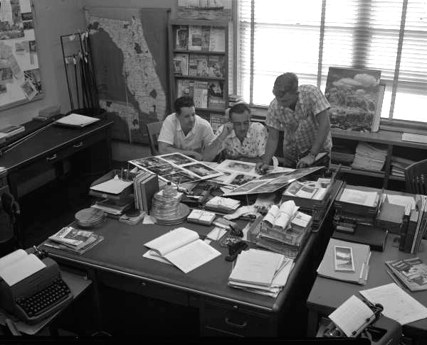 View of Florida News Bureau employees in an office looking at photographs.